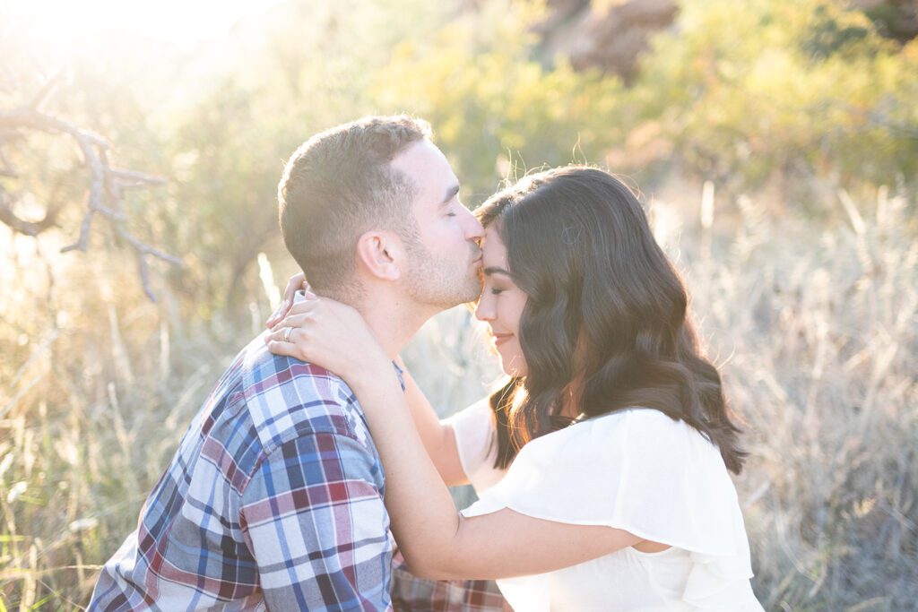 man kissing woman forehead